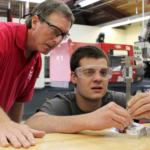 Mechanical Engineering student with a professor taking measurements.