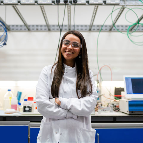 Young woman dressed in white gown in medical lab.