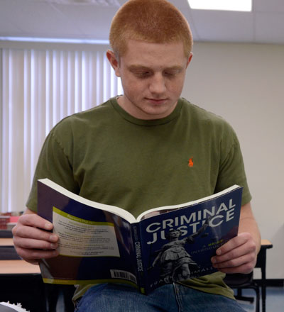 Cayuga student reading an assignment