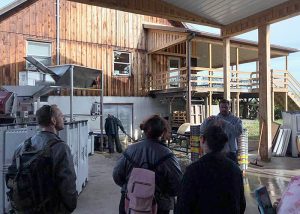 Students at the Buttonwood Grove Winery looking at the equipment outside the winery